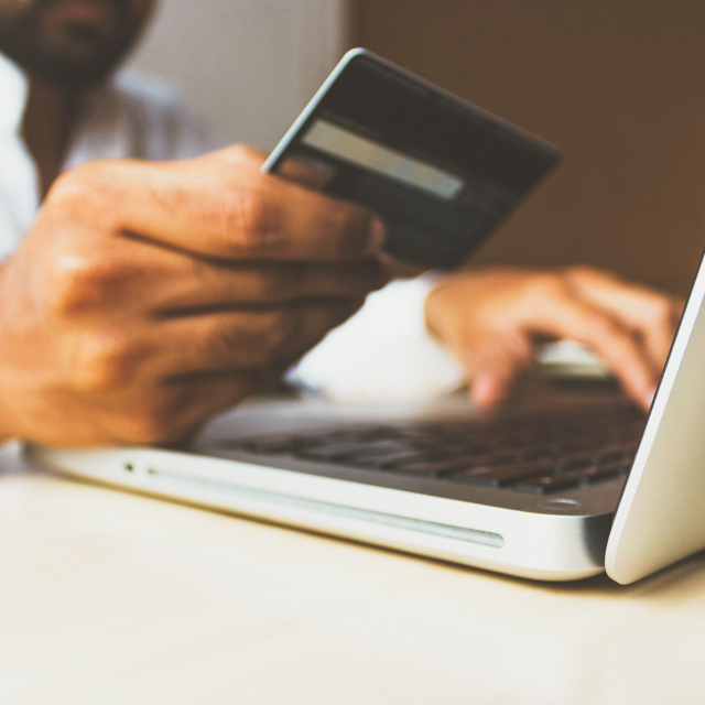 Closeup of man shopping online using credit card