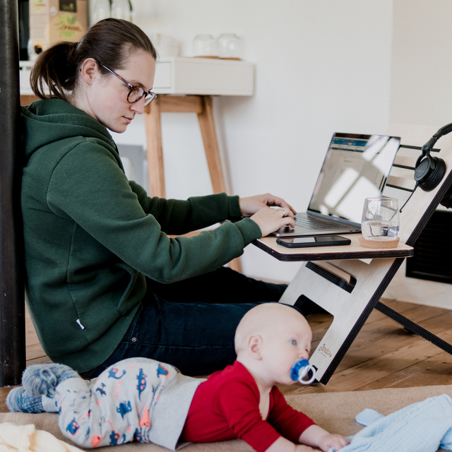 Woman working from home while caring for a baby