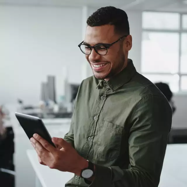 Man smiling and looking at tablet