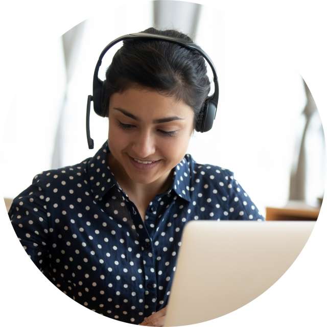 Woman wearing headset and using Conga's Commerce Suite on laptop
