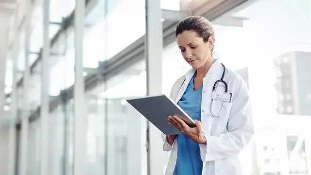 Doctor looking at ipad to review Medtech renewal contracts