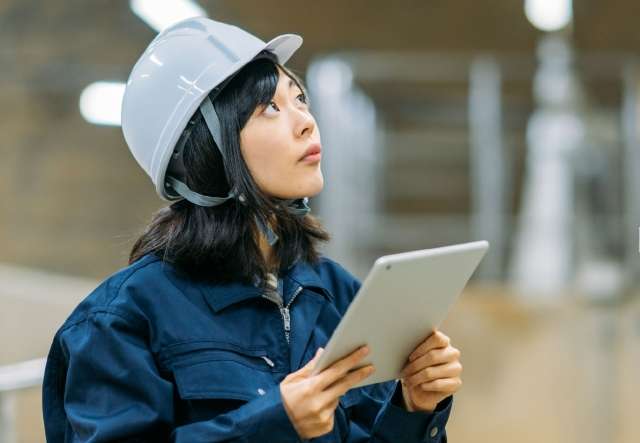 Woman wearing helmet and holding tablet