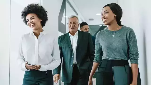 Coworkers smiling and walking in office