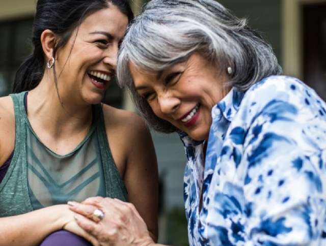 Two woman holding hands and laughing