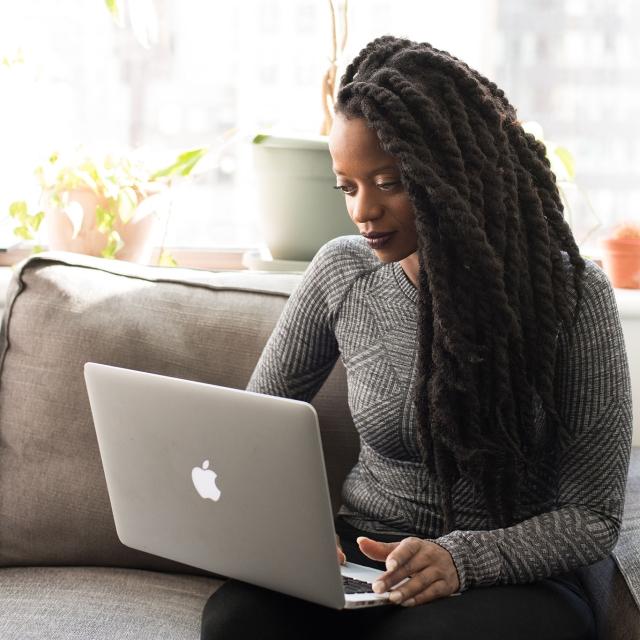 Woman looking at laptop on her couch