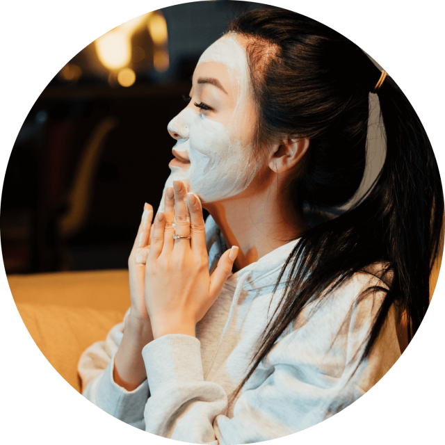 Young woman applying a face mask