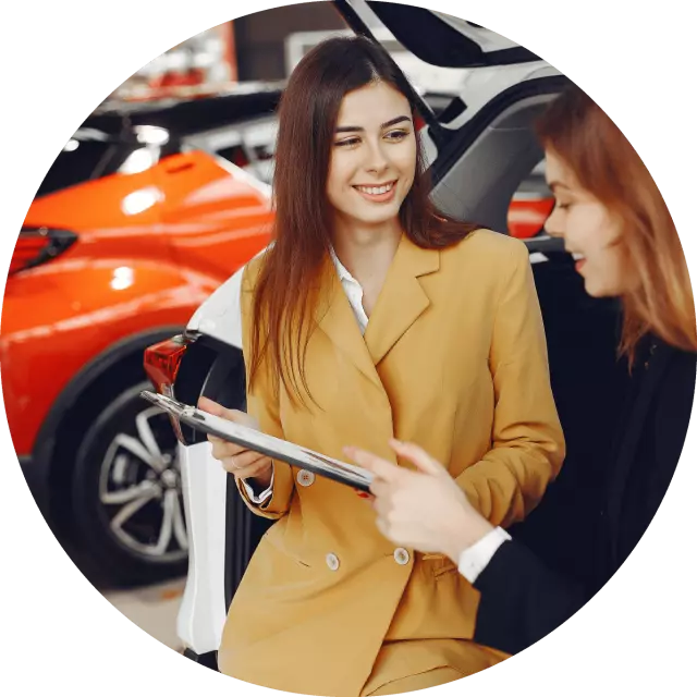 Woman selling another woman a car at a dealership