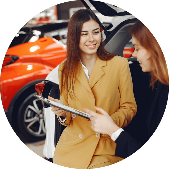 Woman selling another woman a car at a dealership