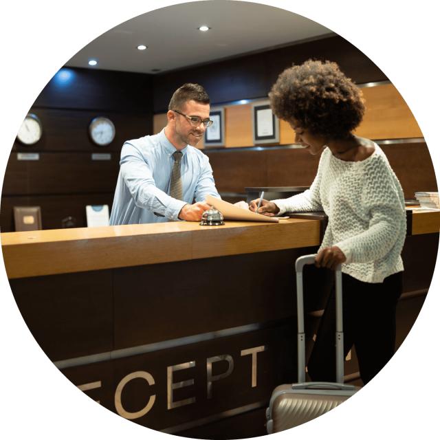 Hotel concierge talking to woman with suit case