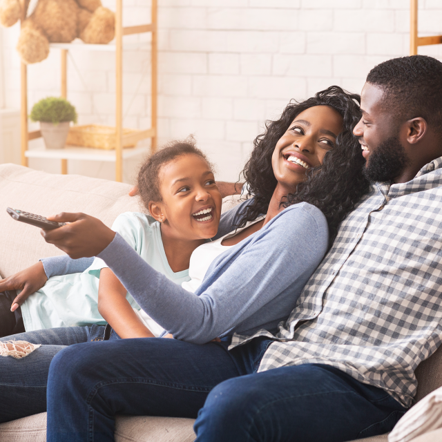 Family laughing on a couch