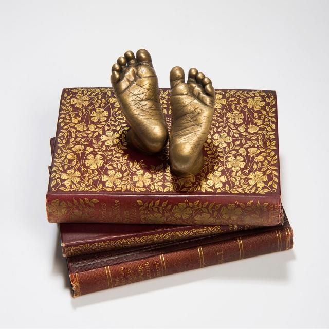 Gold statue of feet on a stack of books