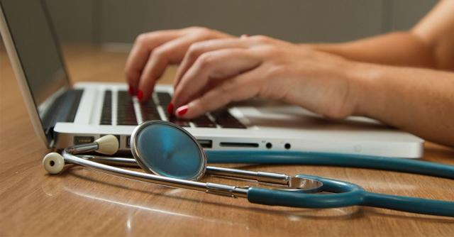 Doctor managing contracts on laptop