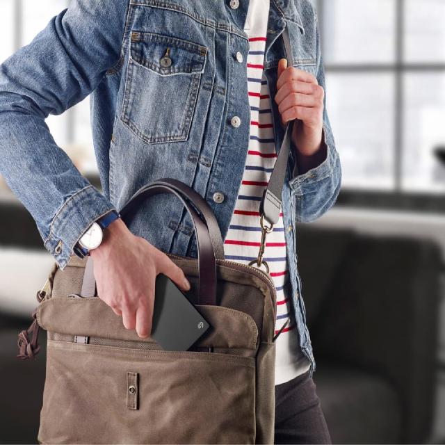 Person slipping cell phone into satchel