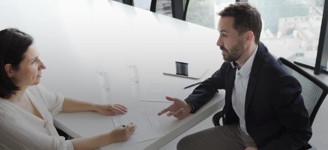 Man and woman talking at conference table