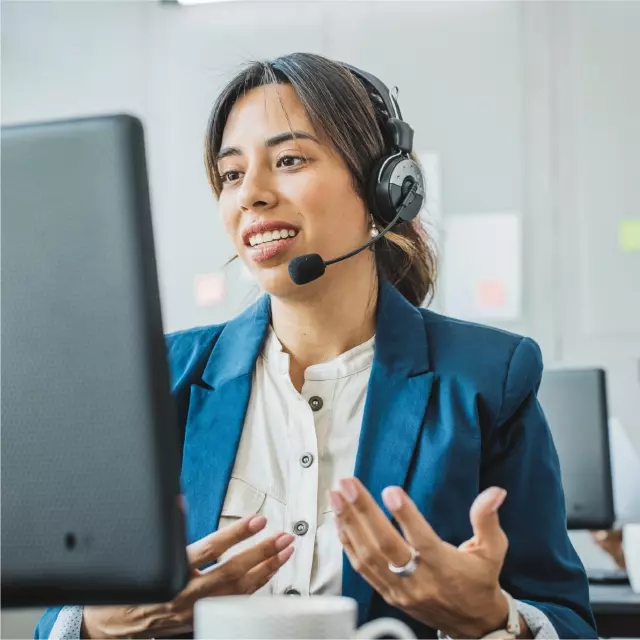 Woman talking on headset looking at computer