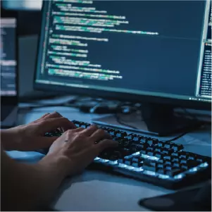 Hands typing code on keyboard
