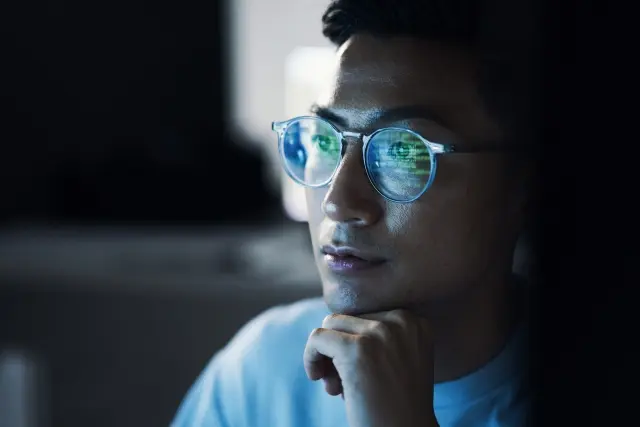 Person wearing glasses looking at screen