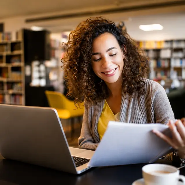 Legal professional reviewing documents on a laptop.