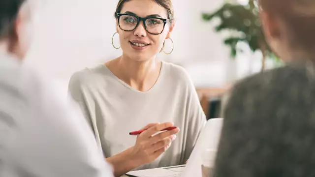 Woman holding a pencil and smiling