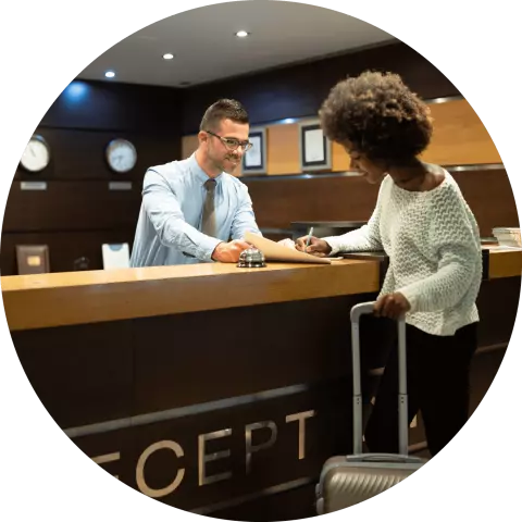 Hotel concierge talking to woman with suit case