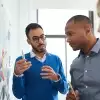 Coworkers using sticky notes on wall