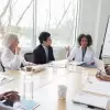 Scientists in lab coats holding a forecasting meeting