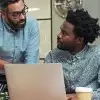 Two men looking at laptop