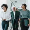 Coworkers smiling and walking in office